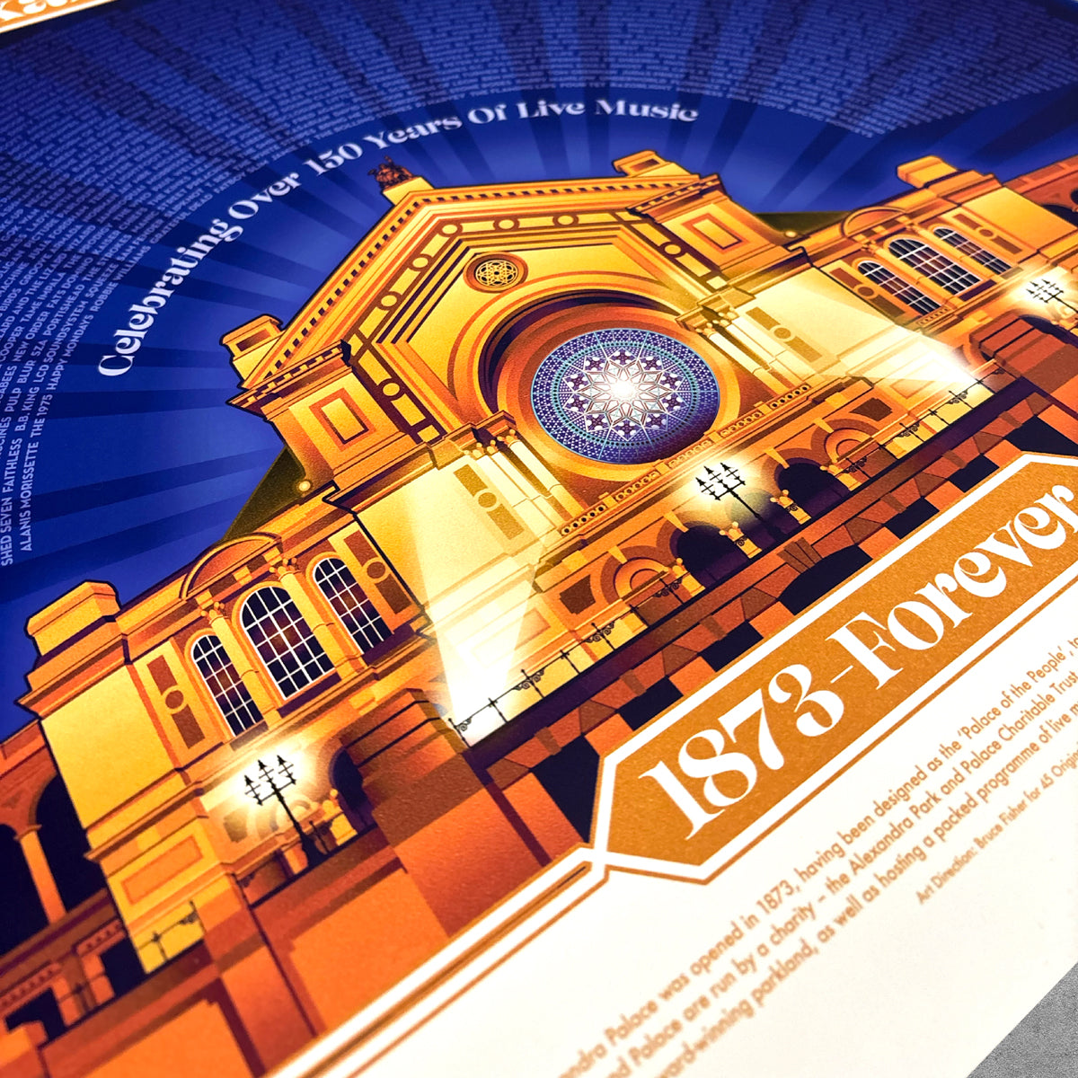 The Alexandra Palace Golden Poster Print - Limited Edition by 45 Original features a vibrant concert hall scene with bright lights, stained-glass window, and the text “Celebrating Over 150 Years Of Live Music” and “1873 Forever”—a tribute to grassroots venues.