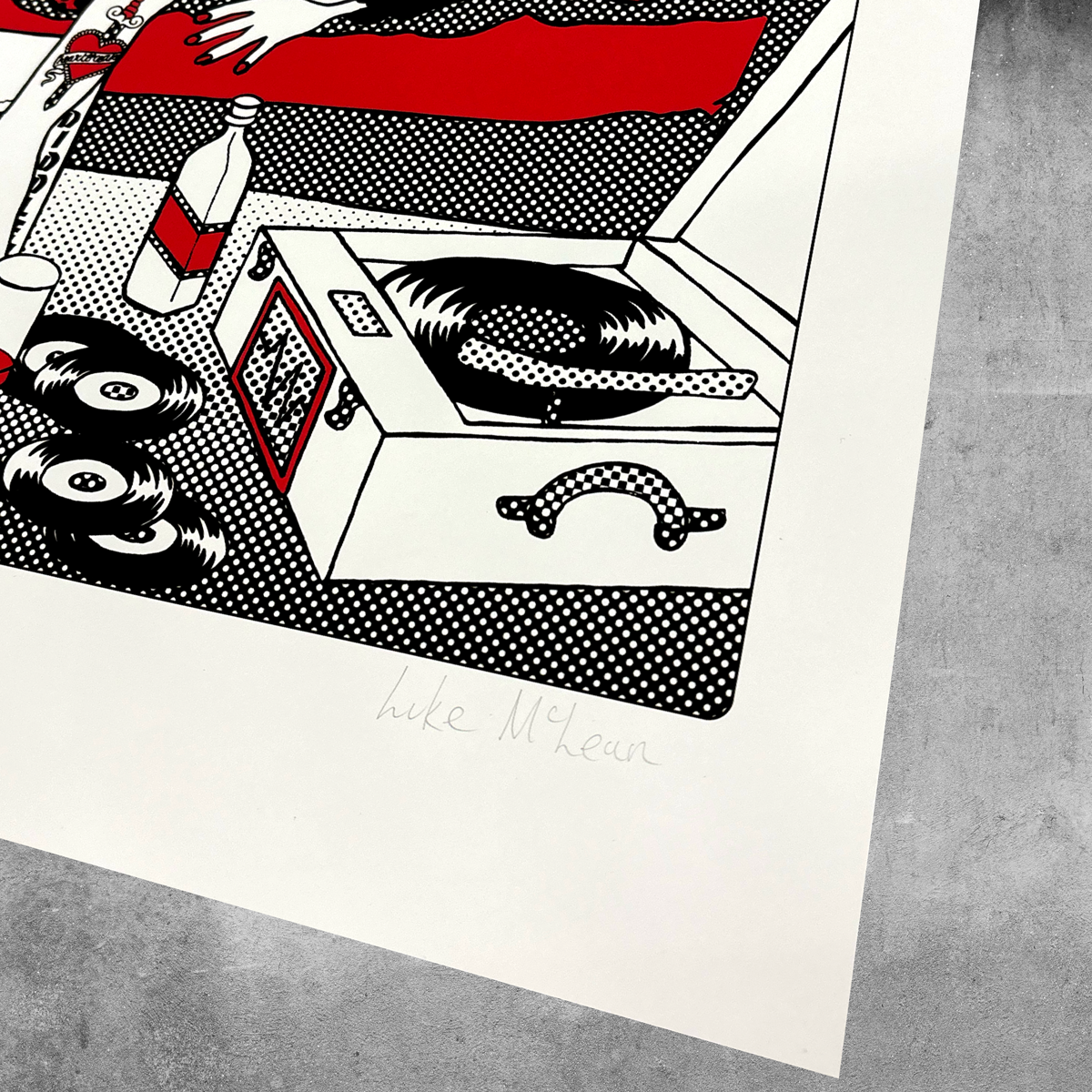 A stylized image of a record player, vinyl, records, and bottle; a hand rests on red. This limited edition Hound Dog Print by My Store is signed by Luke McLean—only 50 available.