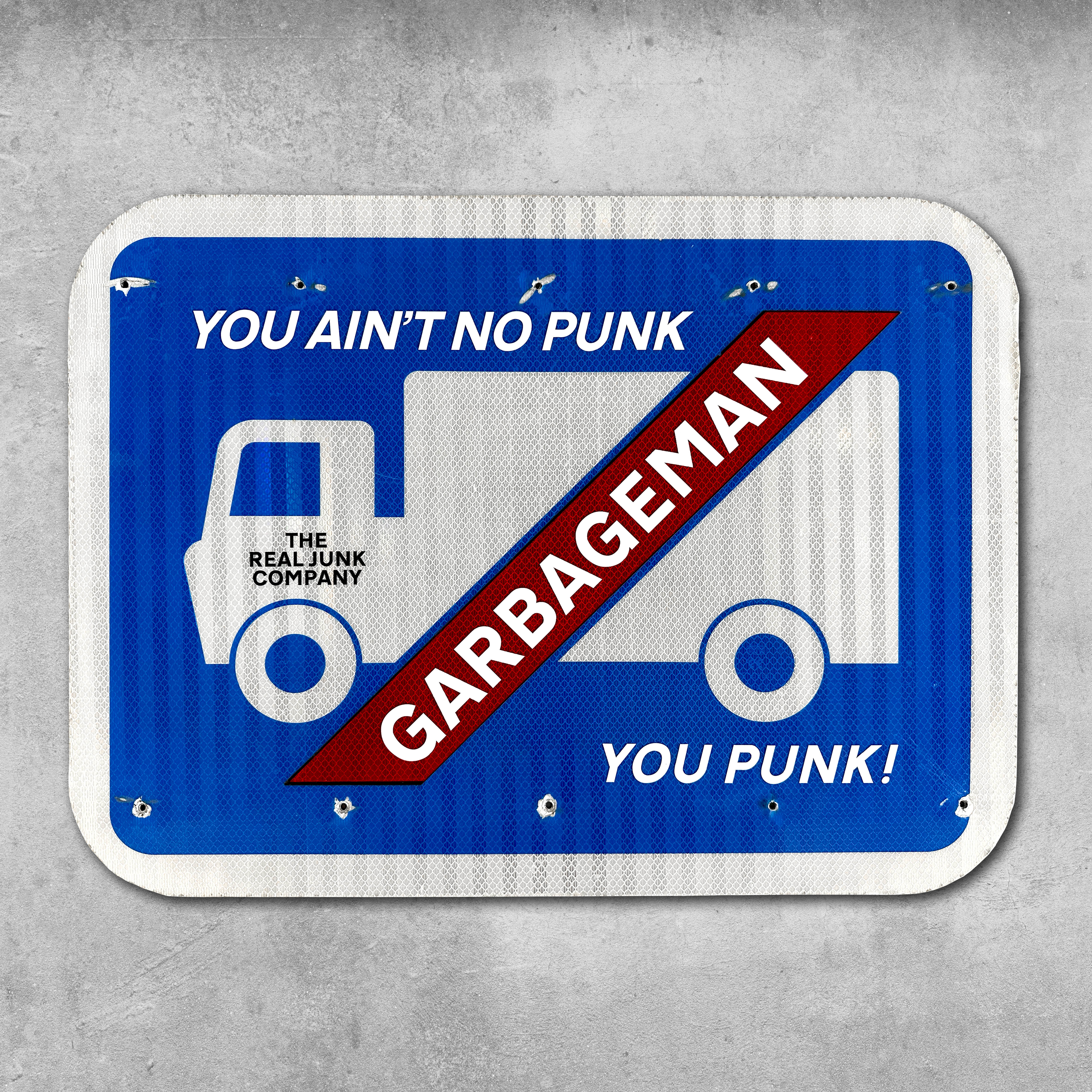 The Original RocknRoad Sign - Garbageman by My Store is a blue UK metal sign with a white garbage truck, bold YOU AINT NO PUNK text, GARBAGEMAN slashed across the truck, and THE REAL JUNK COMPANY below—great for your man cave.