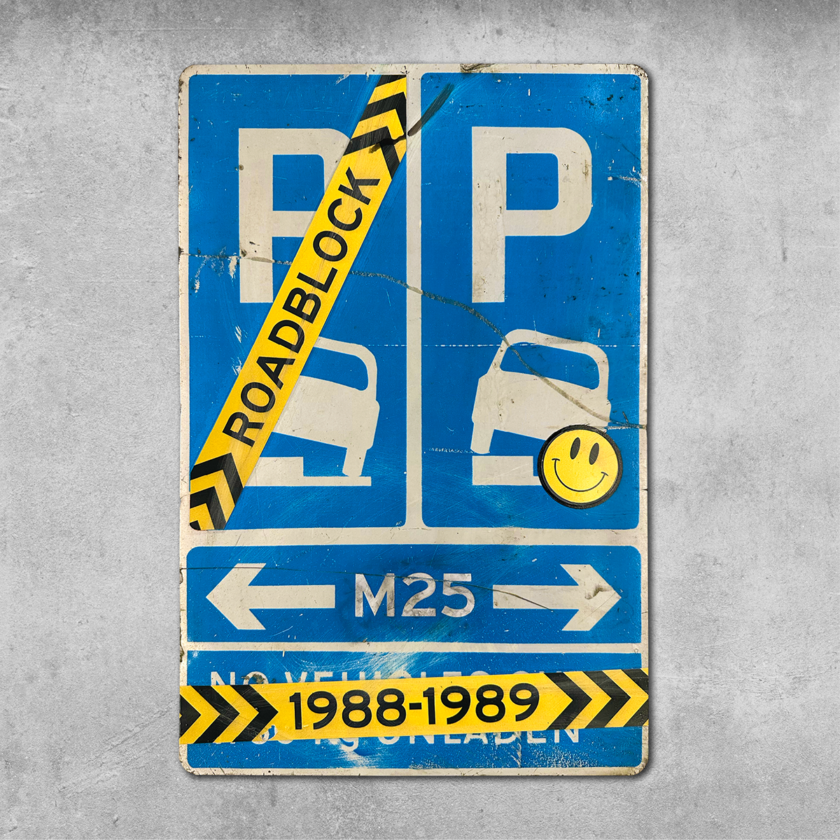 The 45 Original RocknRoad Sign - Roadblock Rave features a blue, worn UK metal sign with yellow-black ROADBLOCK tape (1988-1989), smiley sticker for rave vibes, and M25 arrows on cracked concrete—Original 45 Treatment.