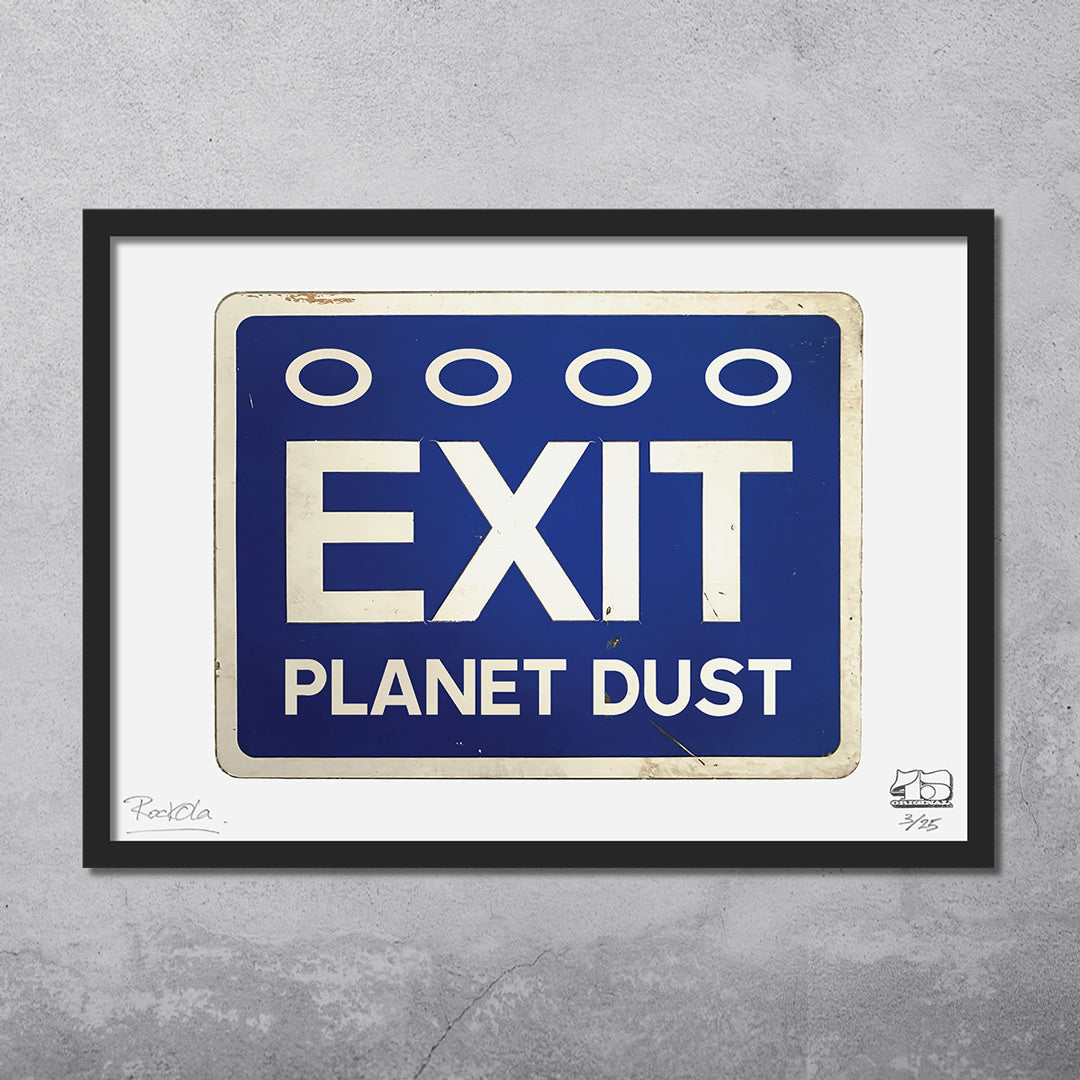The RocknRoad Sign Print - Exit Planet Dust by My Store is a limited edition giclée (25 total), featuring framed artwork of a blue road sign with “EXIT PLANET DUST” and white ovals, all set against a concrete wall backdrop.